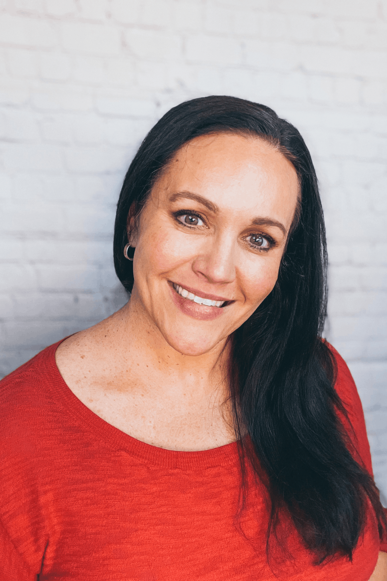 smiling woman with a red shirt who leads burned out dental hygienists on a career pivot